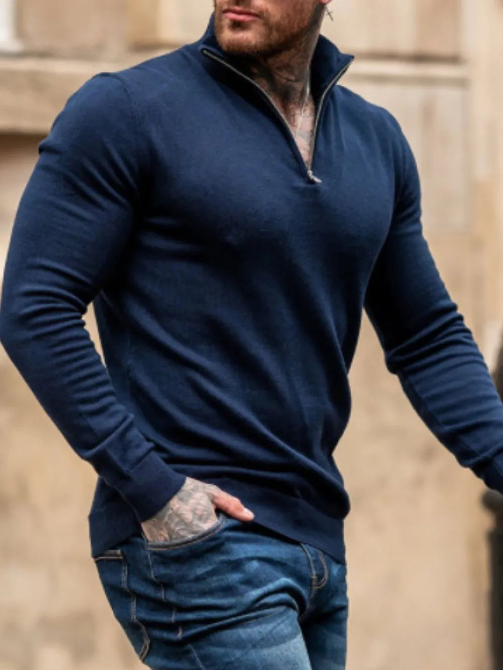 Man wearing a navy blue quarter zip long sleeve knit top  