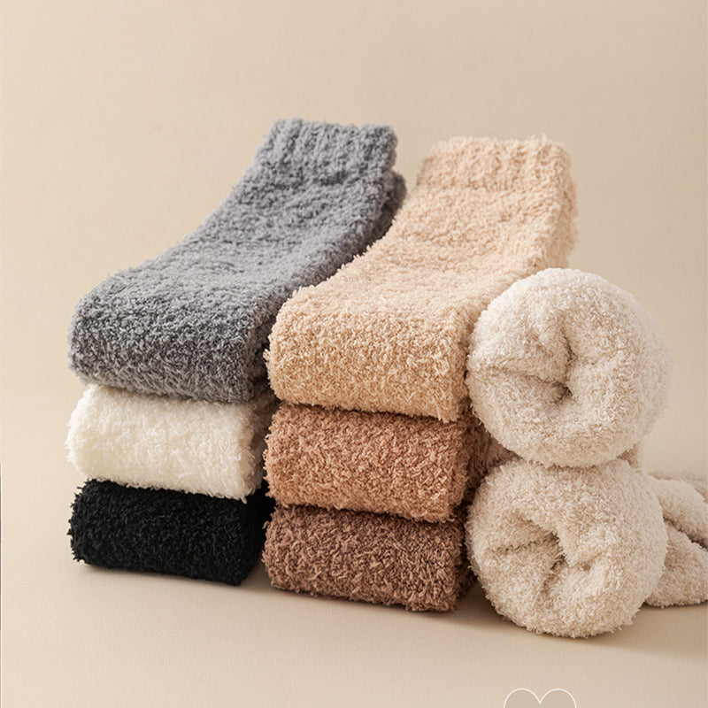 Stack of fluffy socks in various colors on a beige background