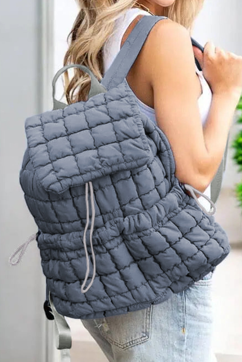 Model wearing a Chic dusk blue Quilted Puffer Flap Backpack on the side