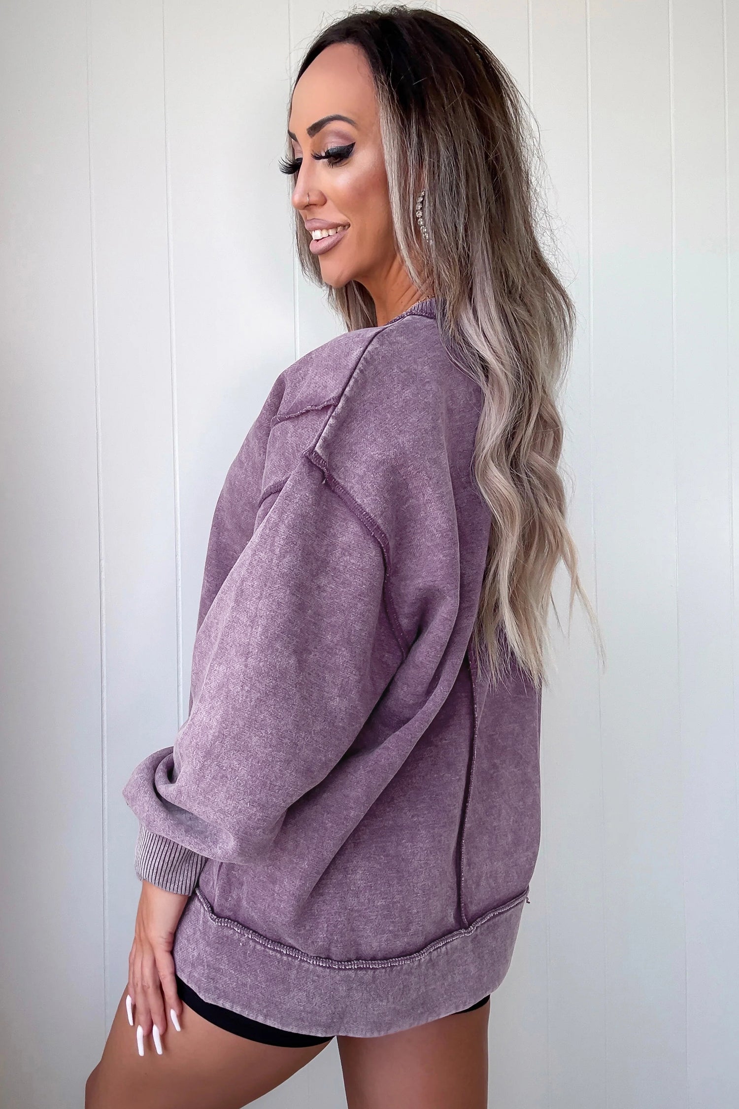 Woman wearing a purple oversized sweater against a white background