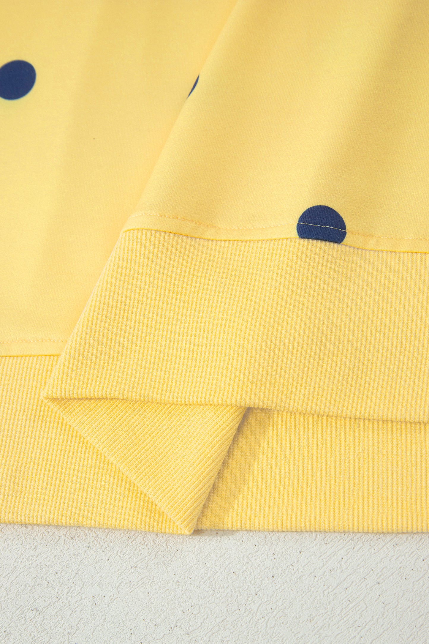 Yellow fabric with blue dots on a textured surface