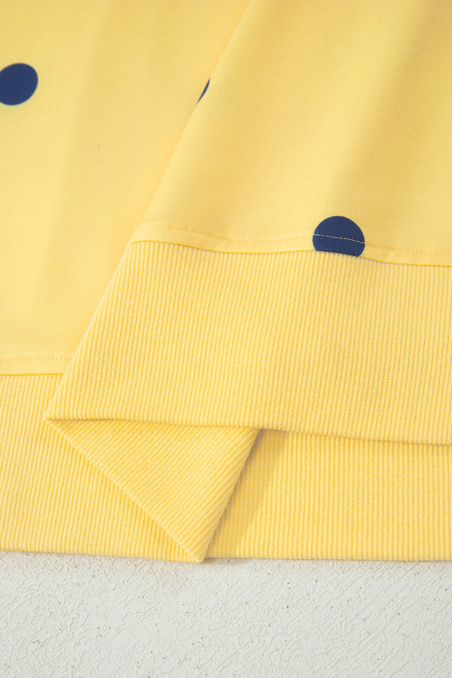 Yellow fabric with blue dots on a textured surface