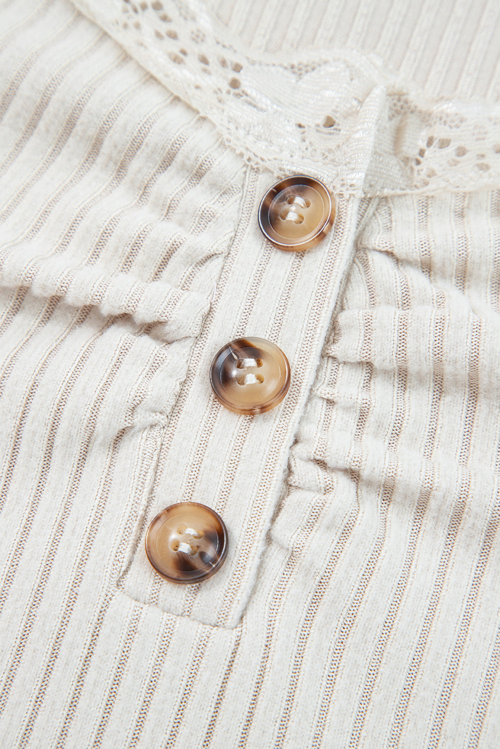Close-up of a textured fabric with buttons on a beige background