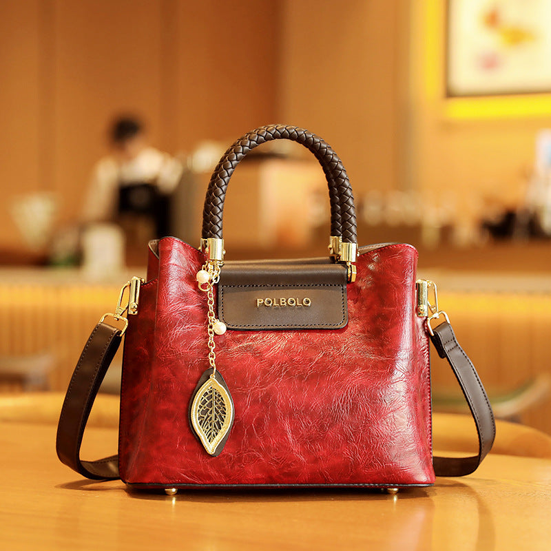 Red handbag with gold accents on a wooden surface, blurred indoor background