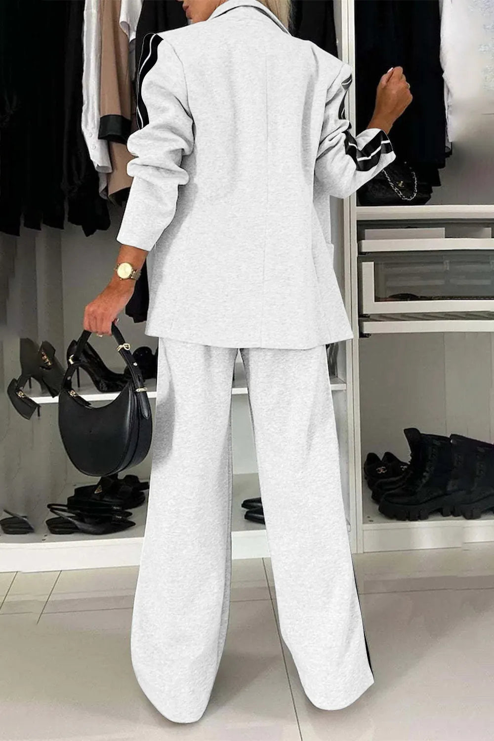 Person wearing a light gray suit in a clothing store.