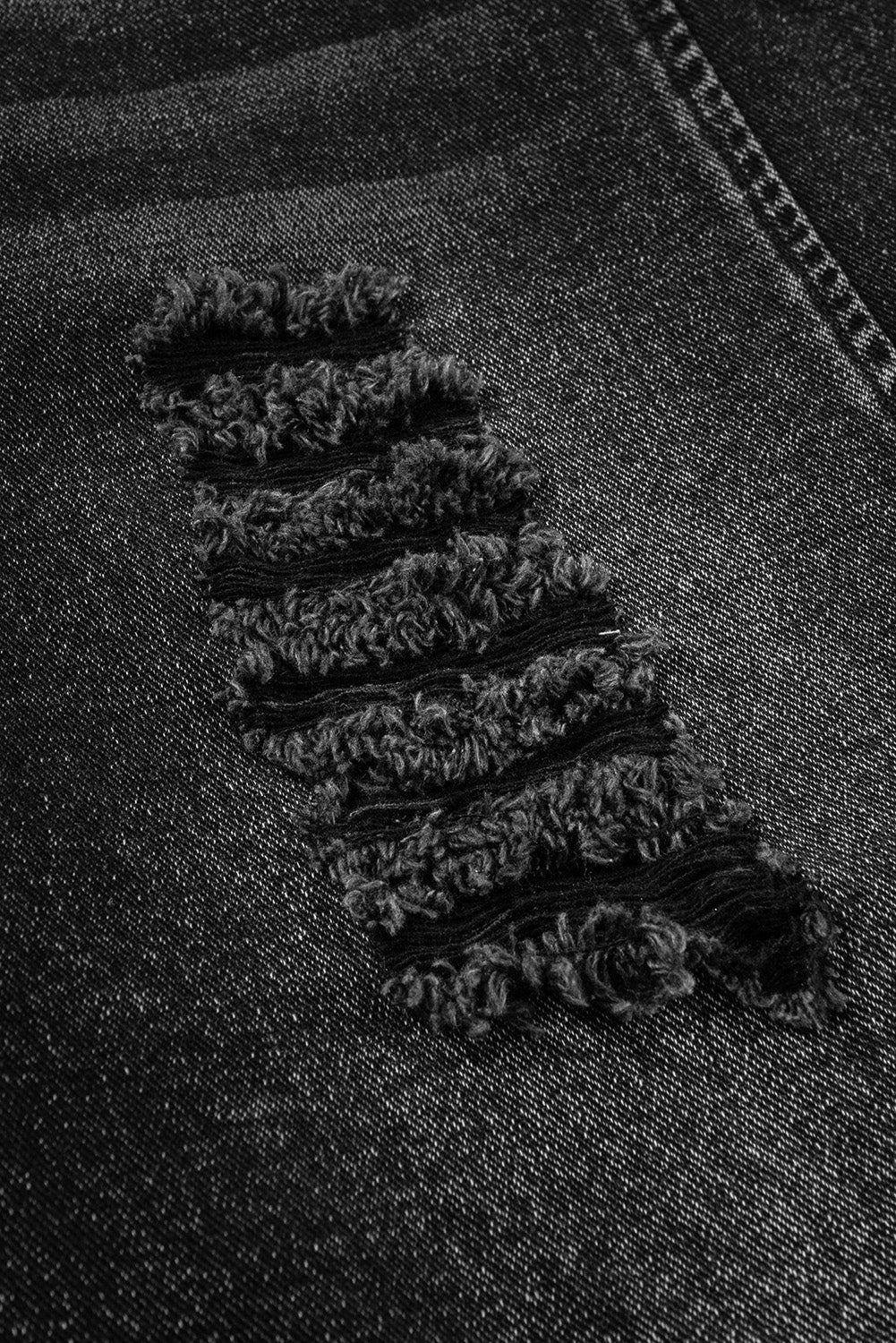 Close-up of a black denim fabric with a subtle pattern