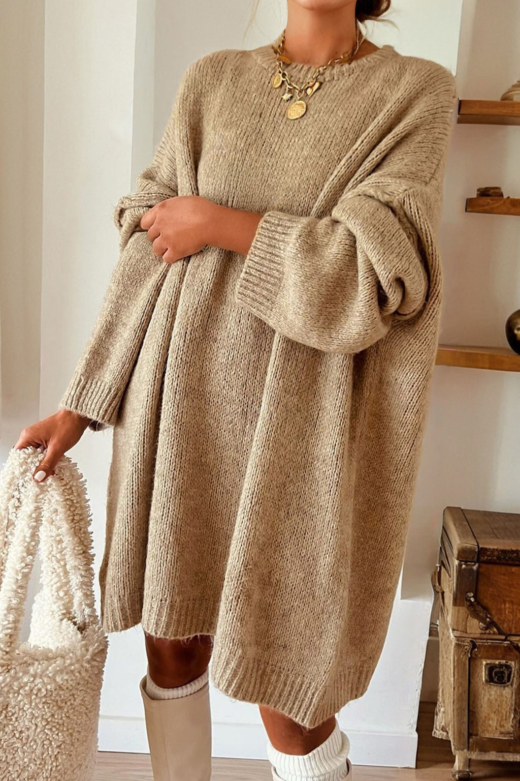 Model wearing a Women's Khaki Exposed Seam Mini Sweater Dress holding a textured handbag.