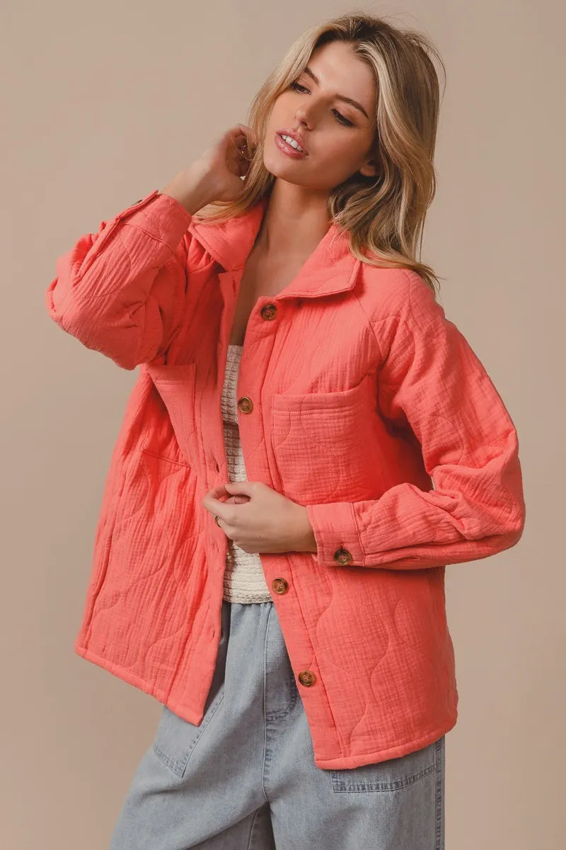 Woman wearing a coral jacket against a beige background 2