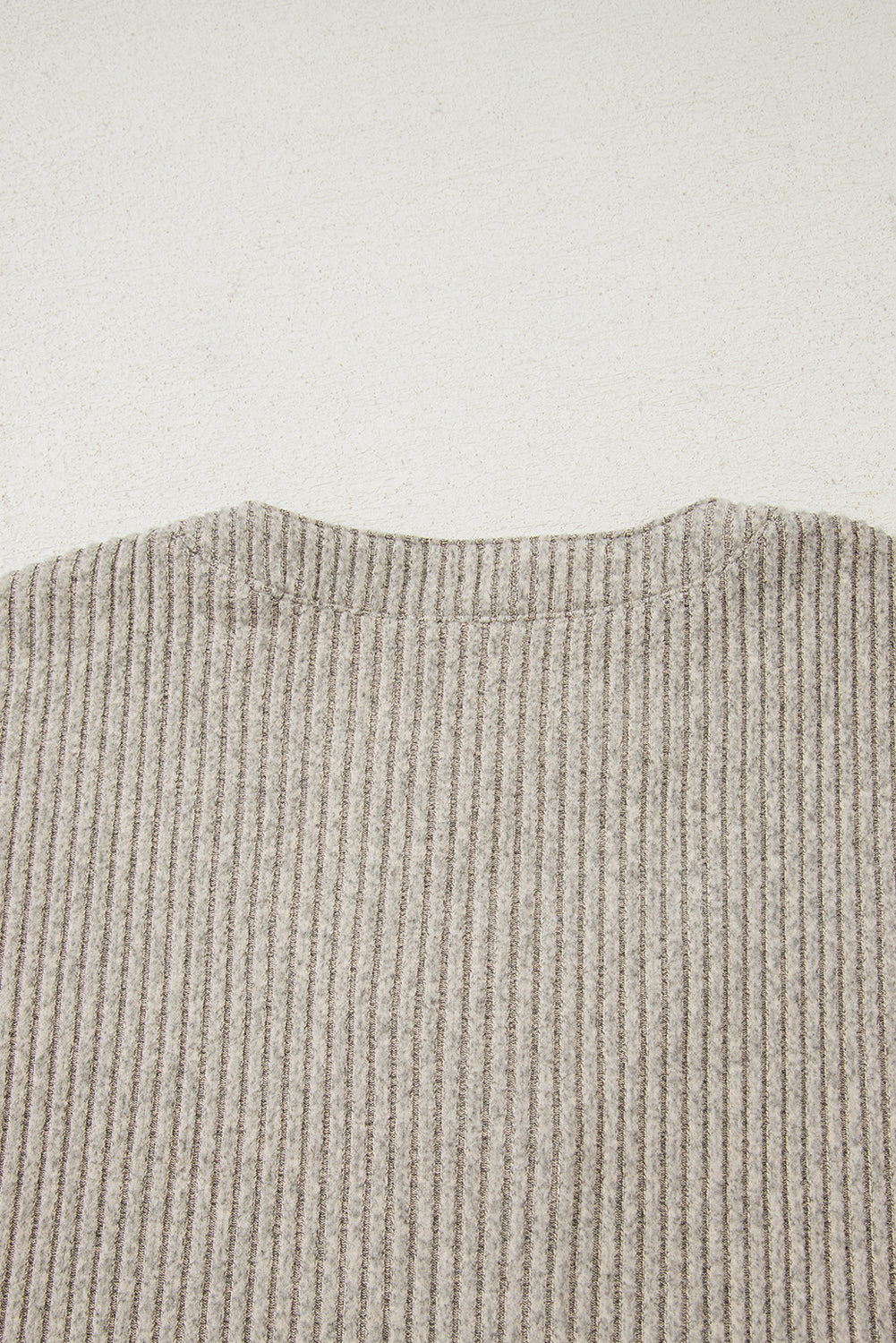Close-up of a textured fabric with a neutral color on a light background