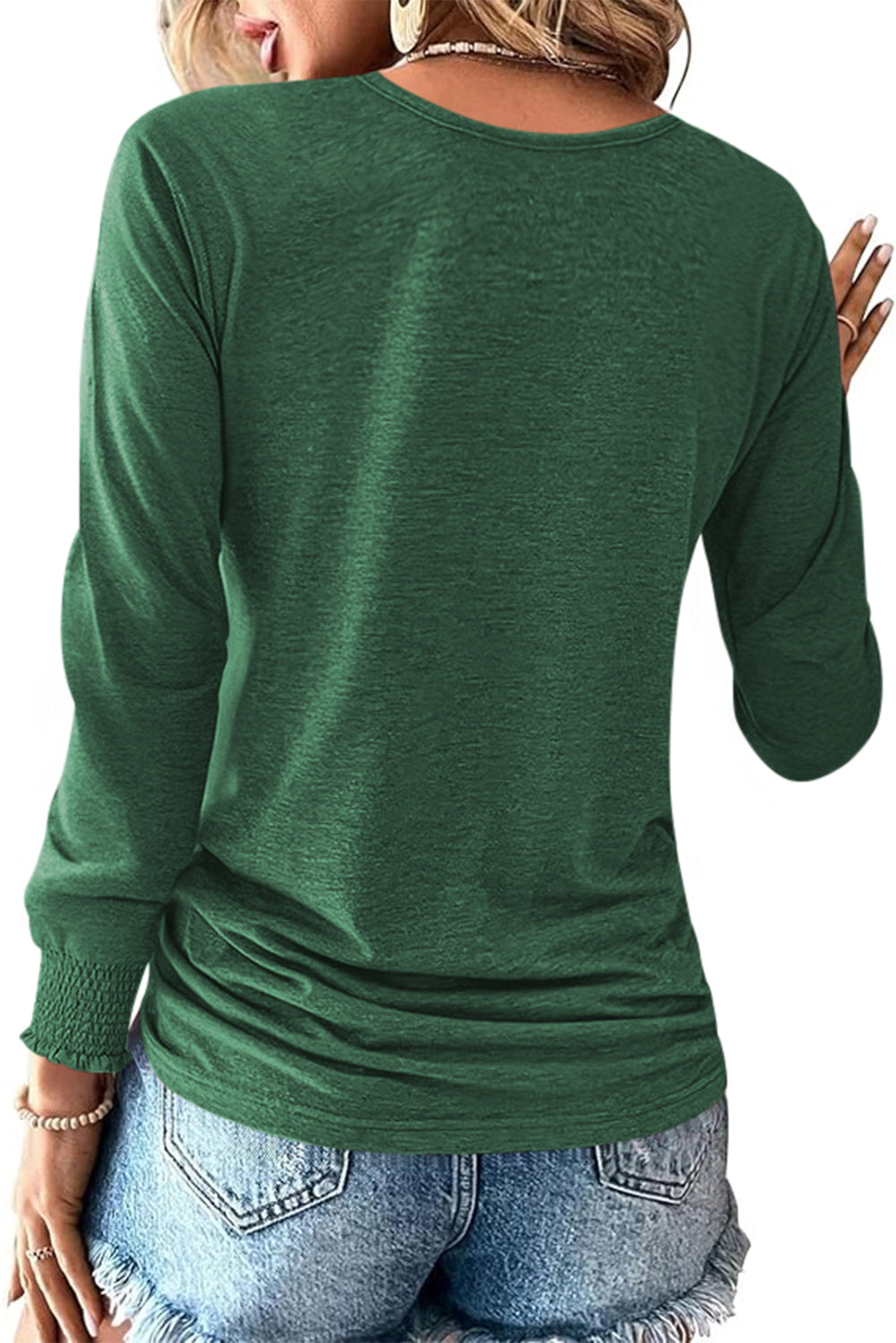 Green long-sleeve top worn by a person, with a focus on the back view.