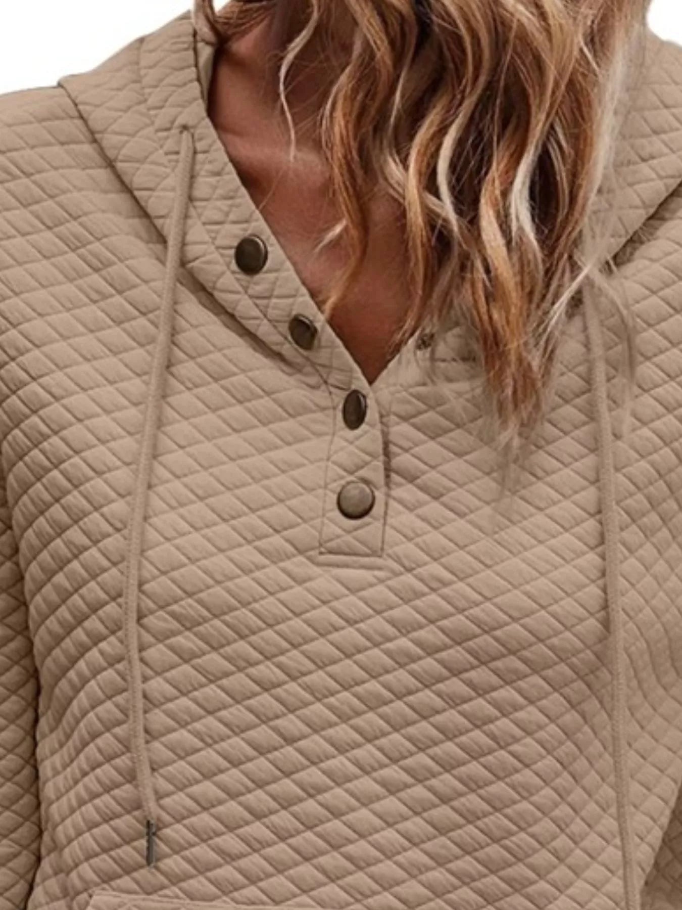 Beige quilted jacket with button details worn by a person