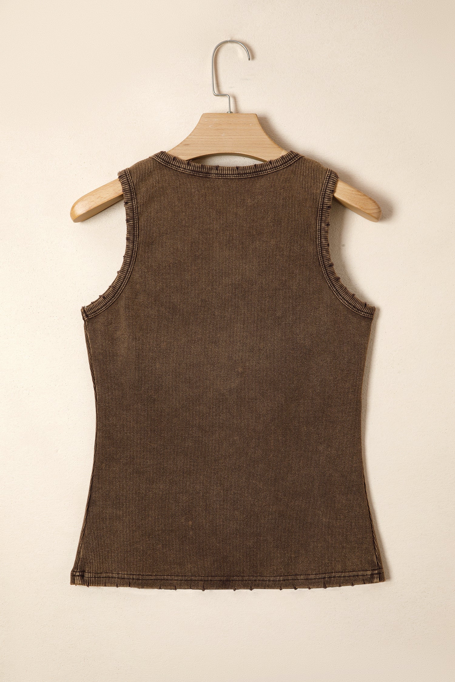 Brown sleeveless top on a wooden hanger against a beige background back