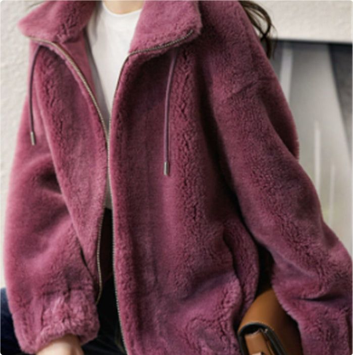Close-up of a person wearing a purple fleece jacket with a blurred background