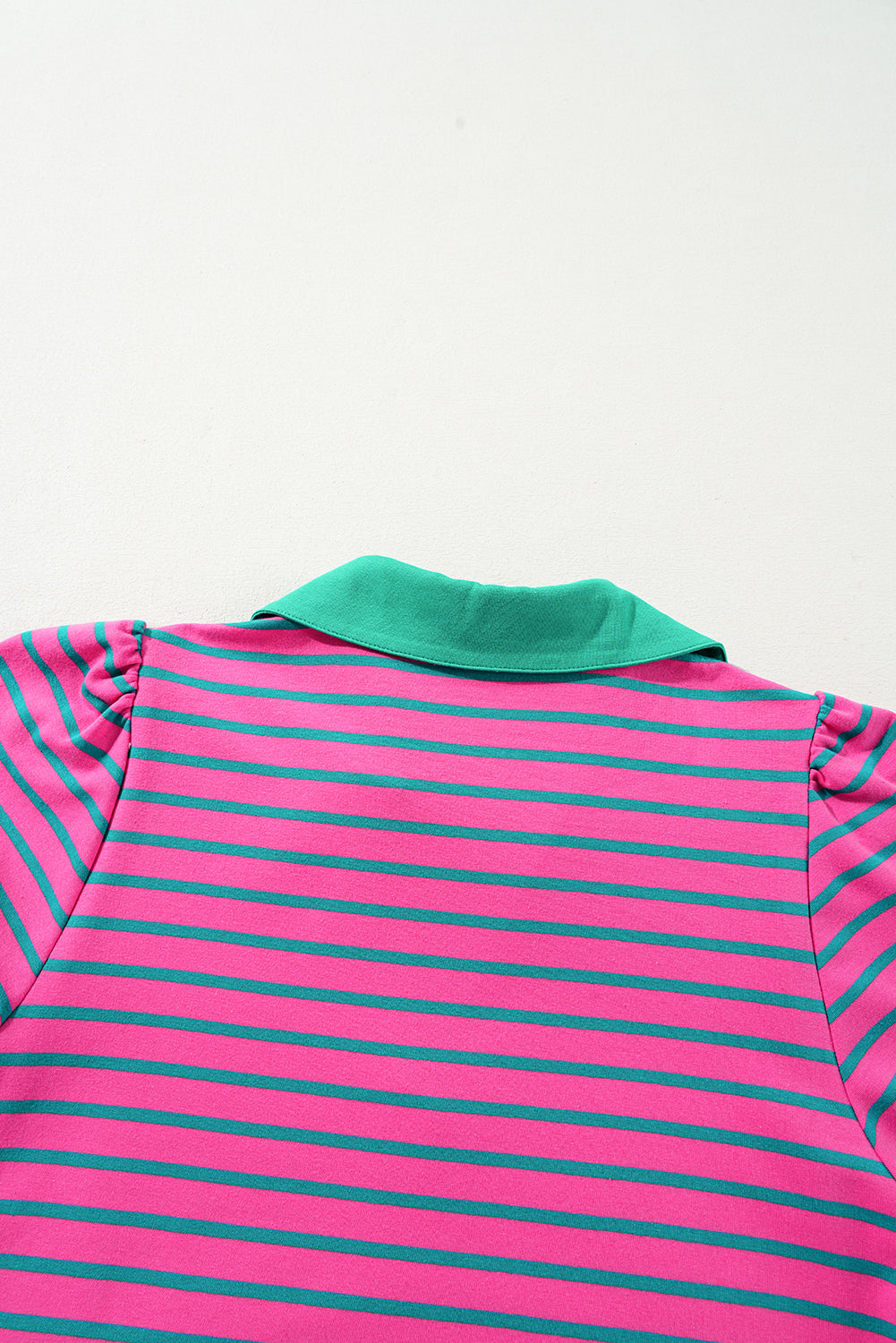 Pink and green striped polo shirt on a white background