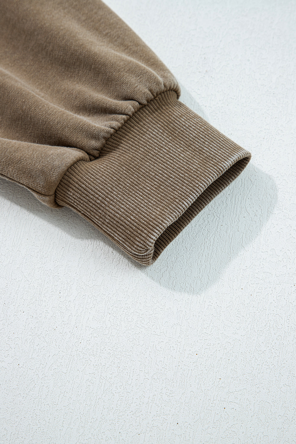 Close-up of brown ribbed knit fabric on a white background