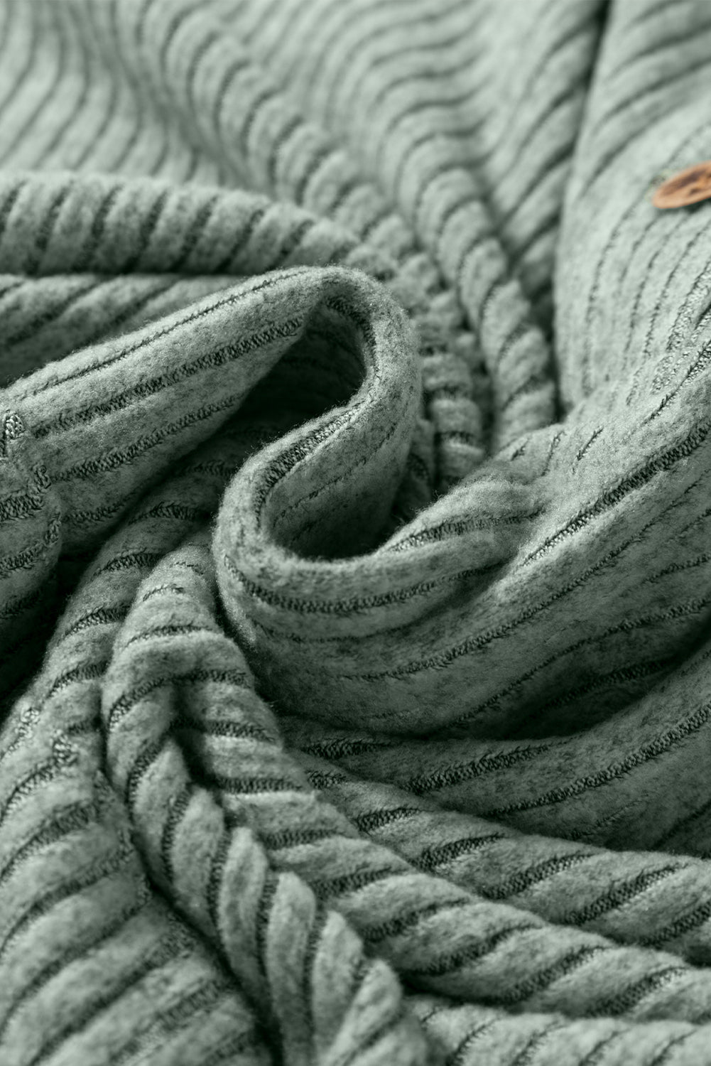 Close-up of textured gray fabric with a button