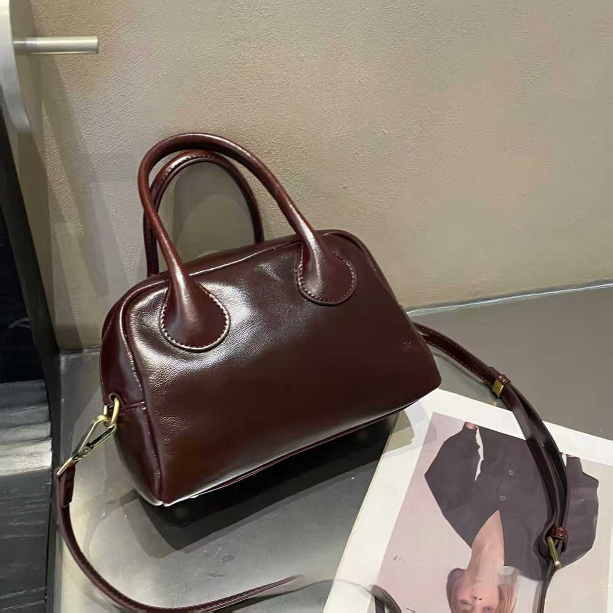 Brown handbag on a metallic surface with a blurred background