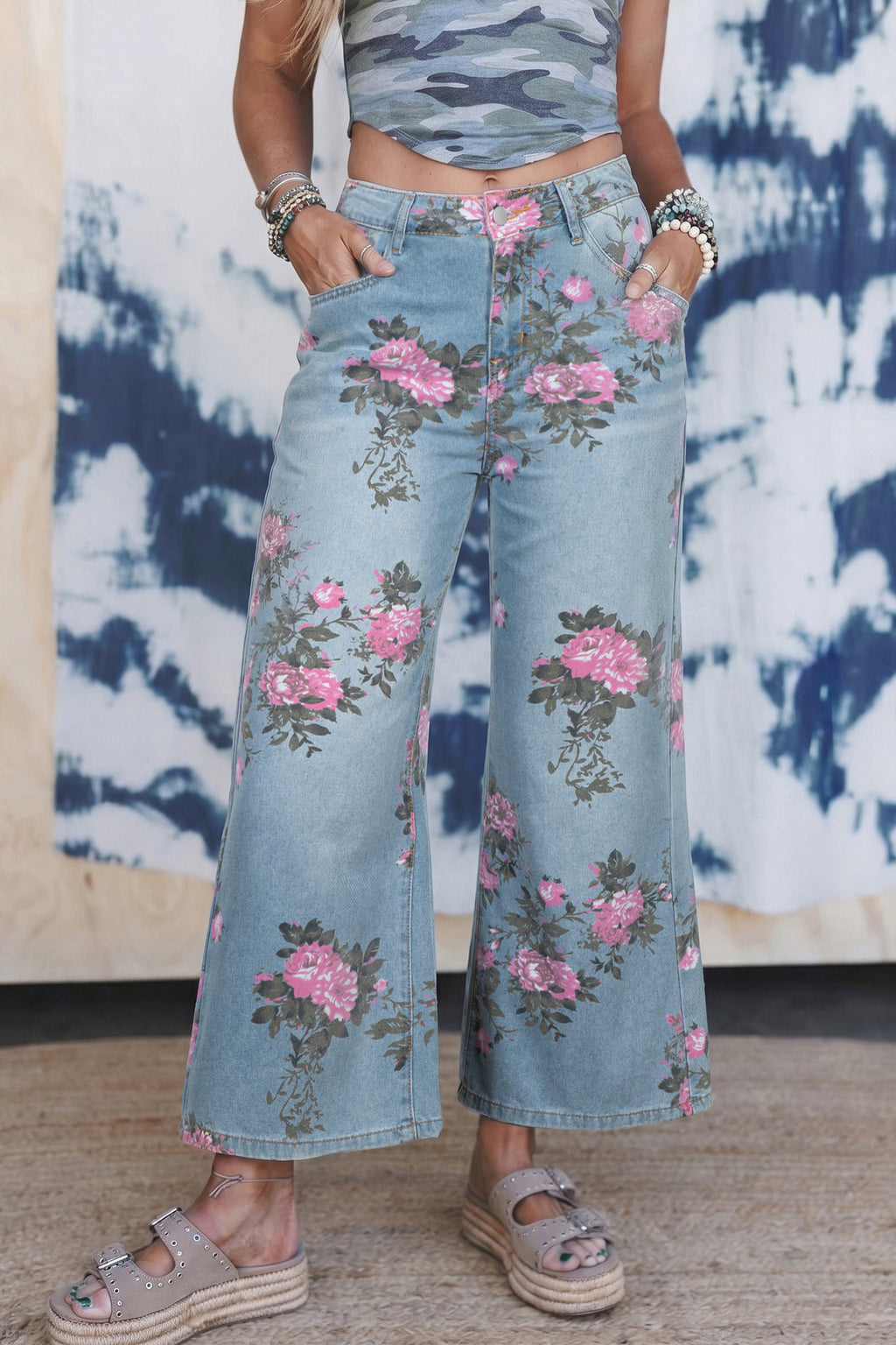 Person wearing floral denim pants with a tie-dye background