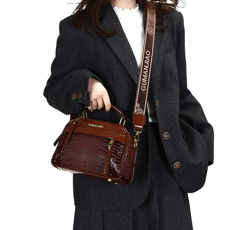 Person holding a brown handbag with a visible brand logo, wearing a dark coat.