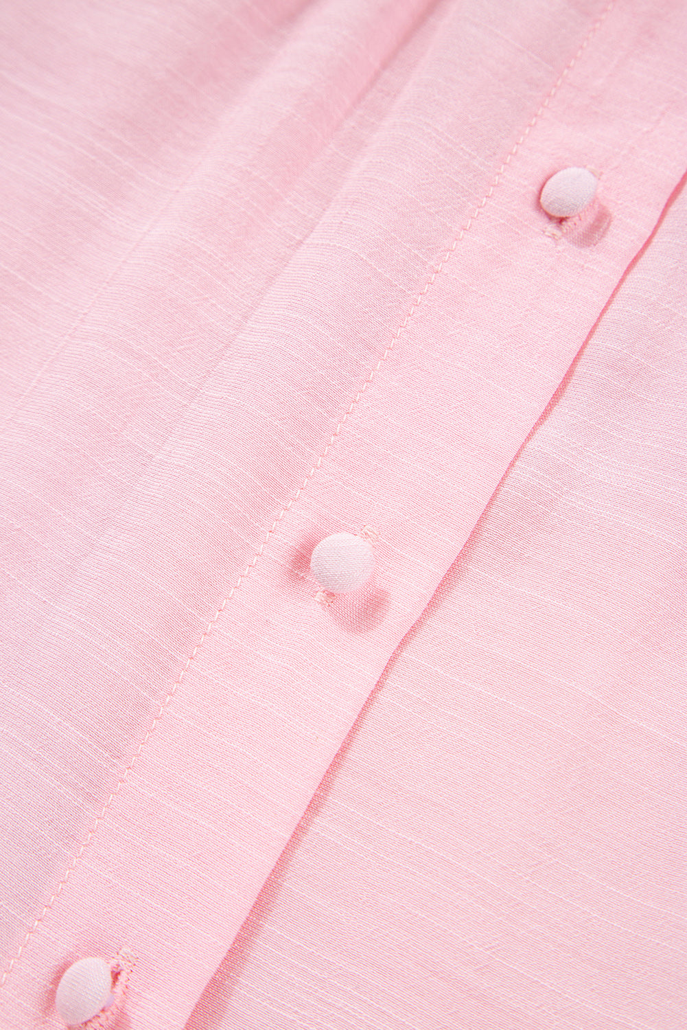 Close-up of a pink textured fabric with buttons