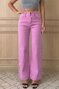 Model wearing pink wide-leg jeans and a gray crop top against a wooden paneled wall.