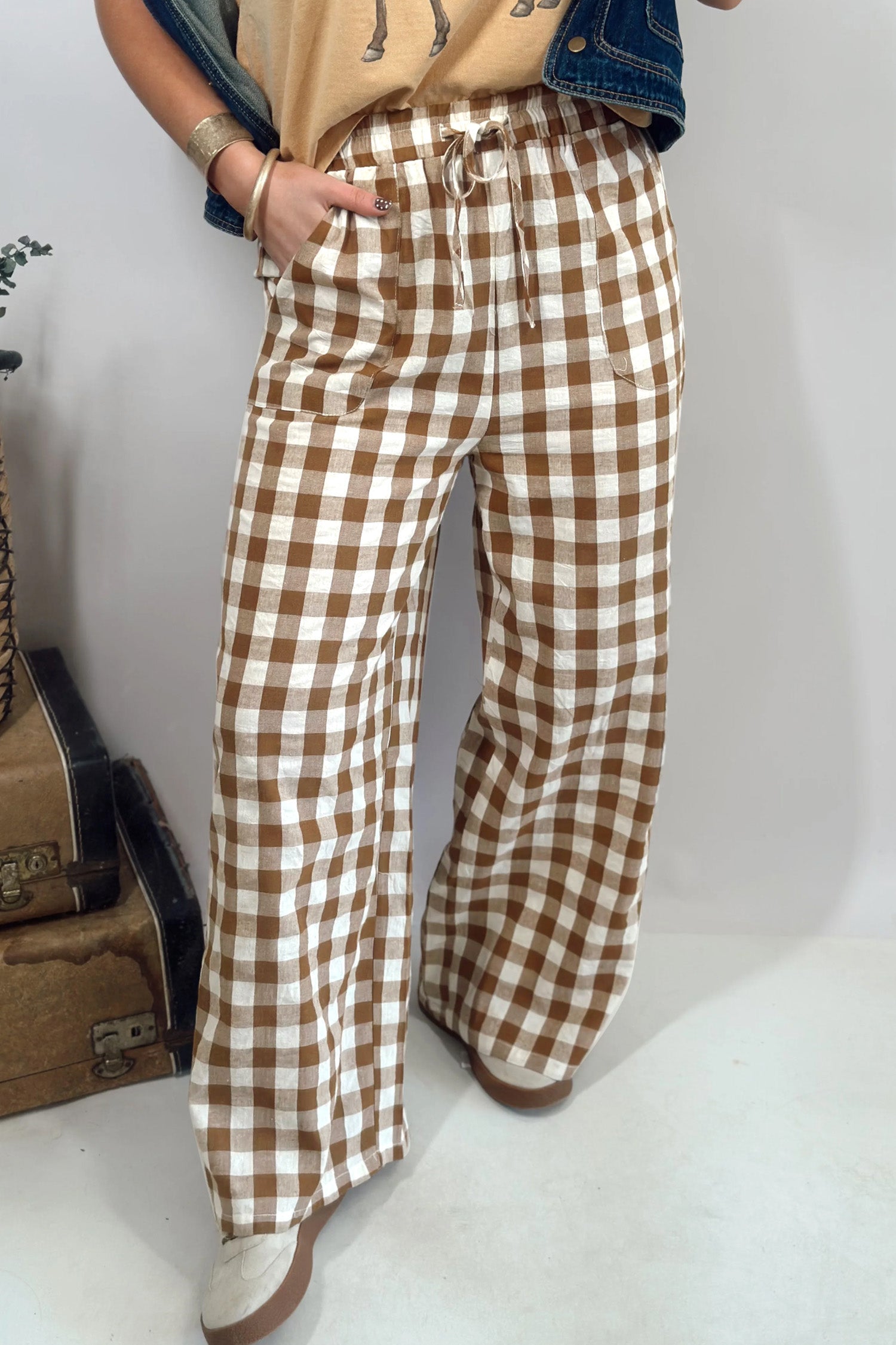 Person wearing brown and white checkered pants on a plain background front view