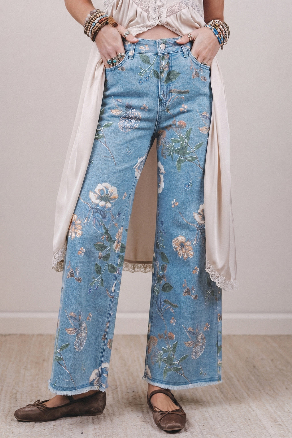 Person wearing floral jeans with a plain background
