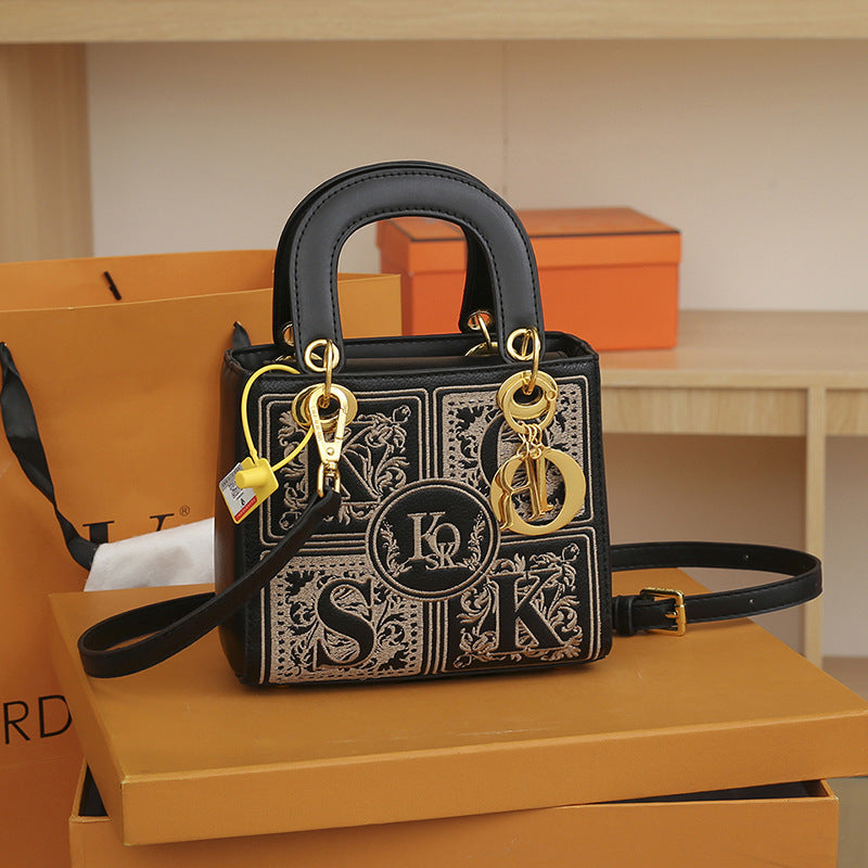Designer handbag with gold hardware on an orange box