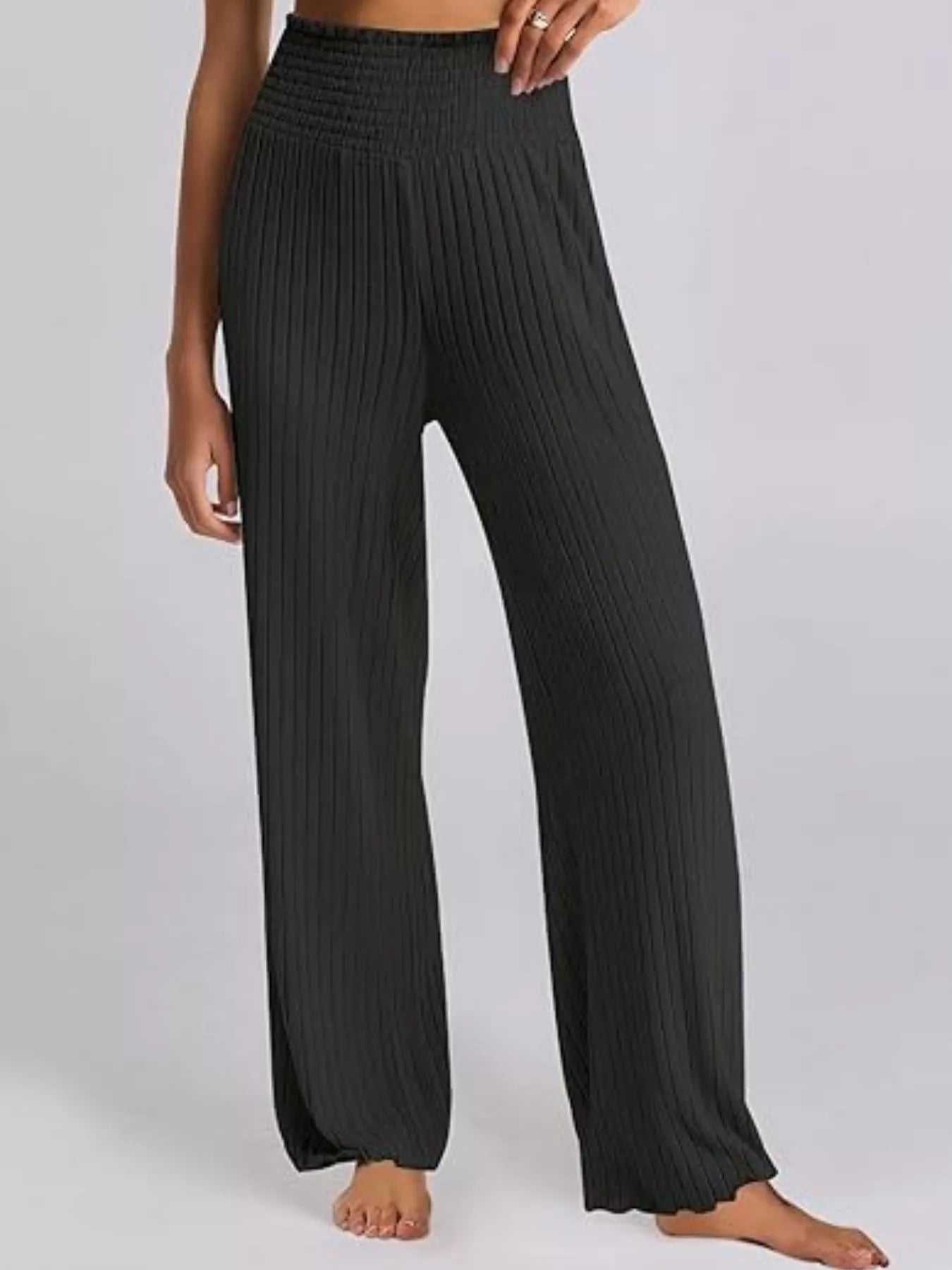 Black ribbed wide-leg pants worn by a person on a white background