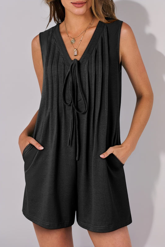 Black sleeveless romper worn by a person on a plain background