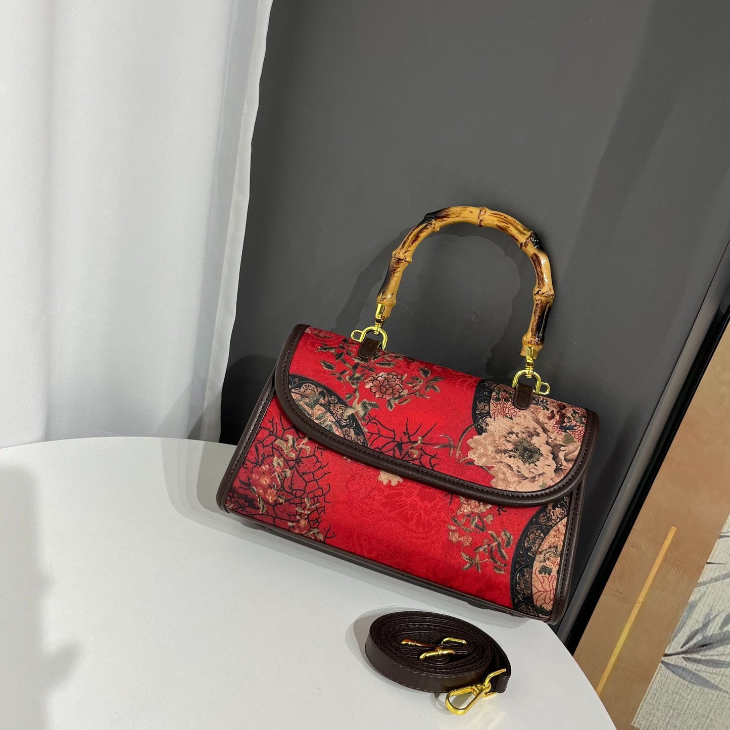 Red handbag with floral patterns on a white surface