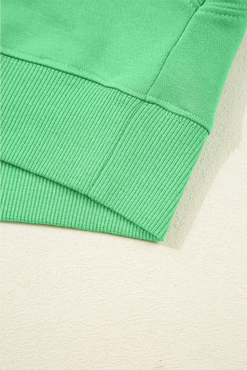 Close-up of a green fabric corner on a beige background