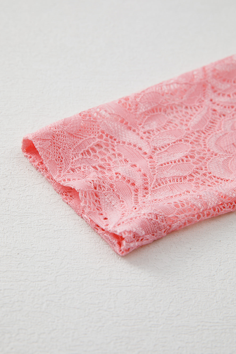 Pink lace fabric on a white background