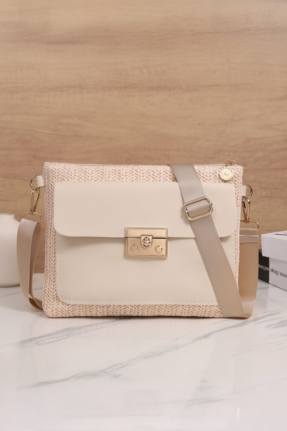 Beige handbag with woven pattern on a light wooden surface