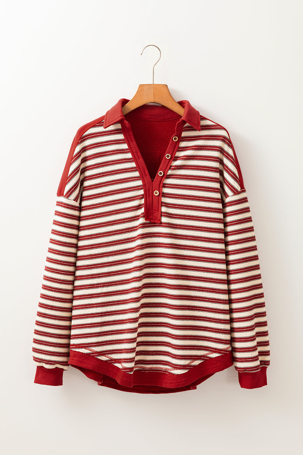 Red and white striped shirt on a hanger against a white background