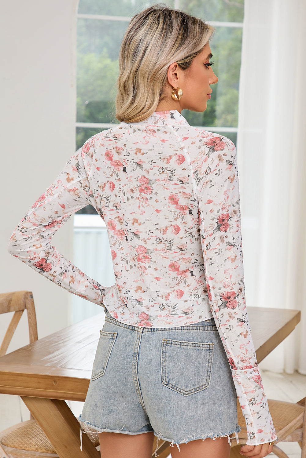 Back view of the model wearing the pink floral top displaying its fit.