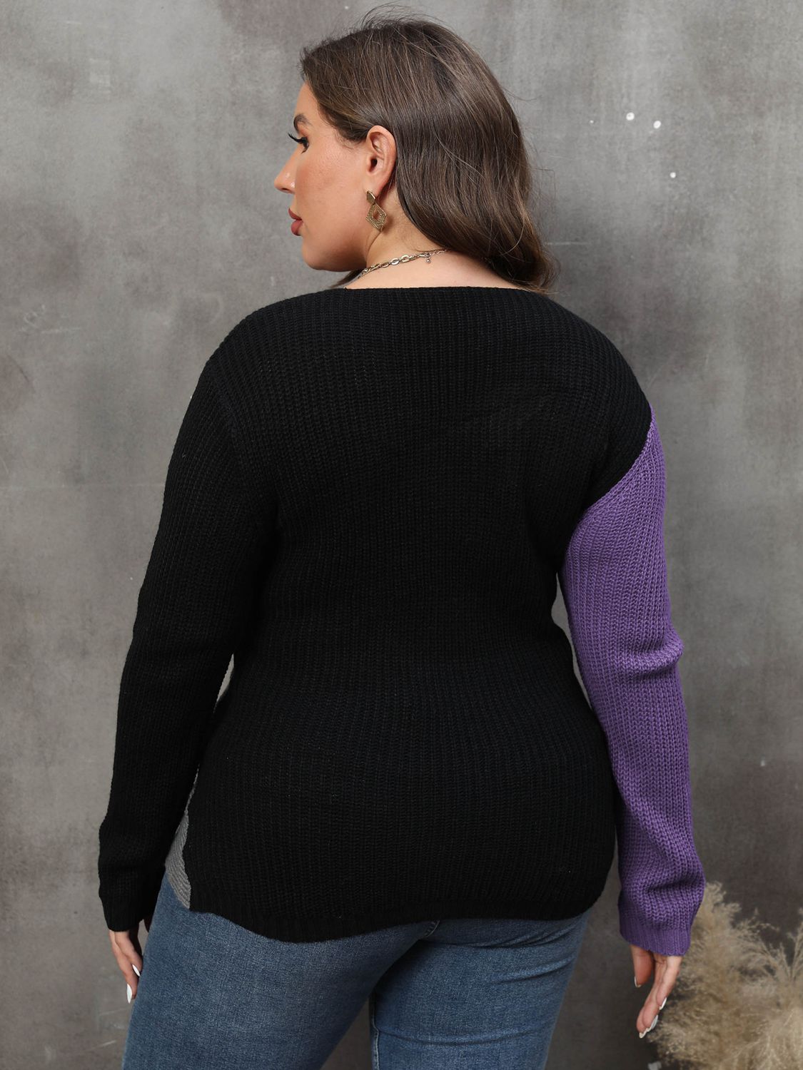 Back view of a model wearing a black and violet colorblock sweater.