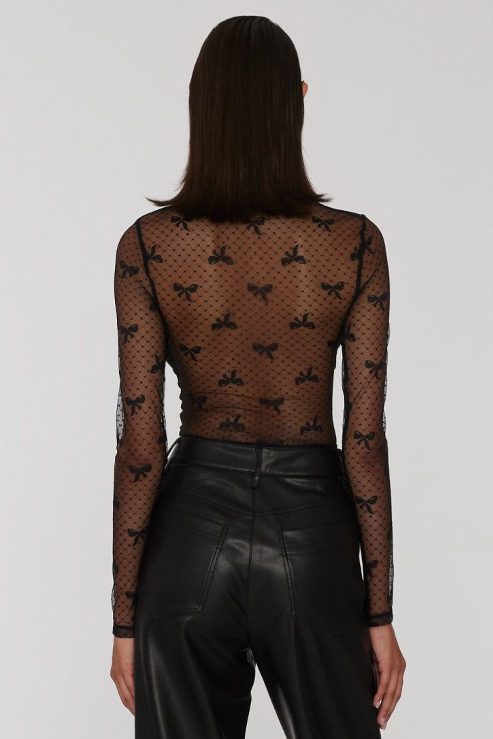 Back view of a model wearing a sheer black lace blouse, highlighting the elegant design and fitted silhouette