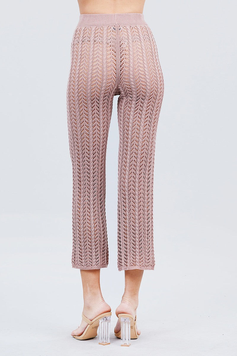 Knitted Blush pink pants worn by a person on a light gray background back view
