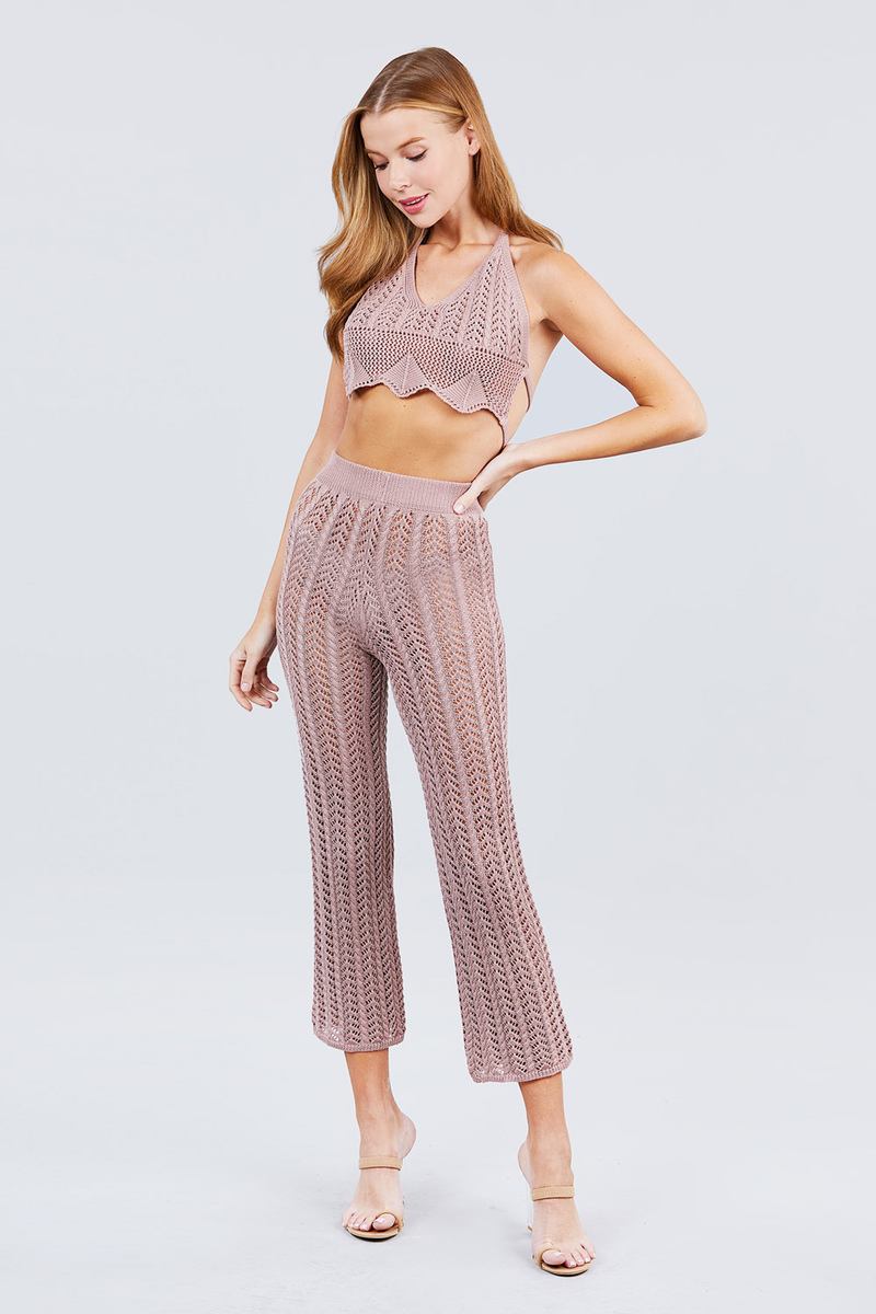 Woman wearing a matching blush pink knit top and pants set on a light gray background