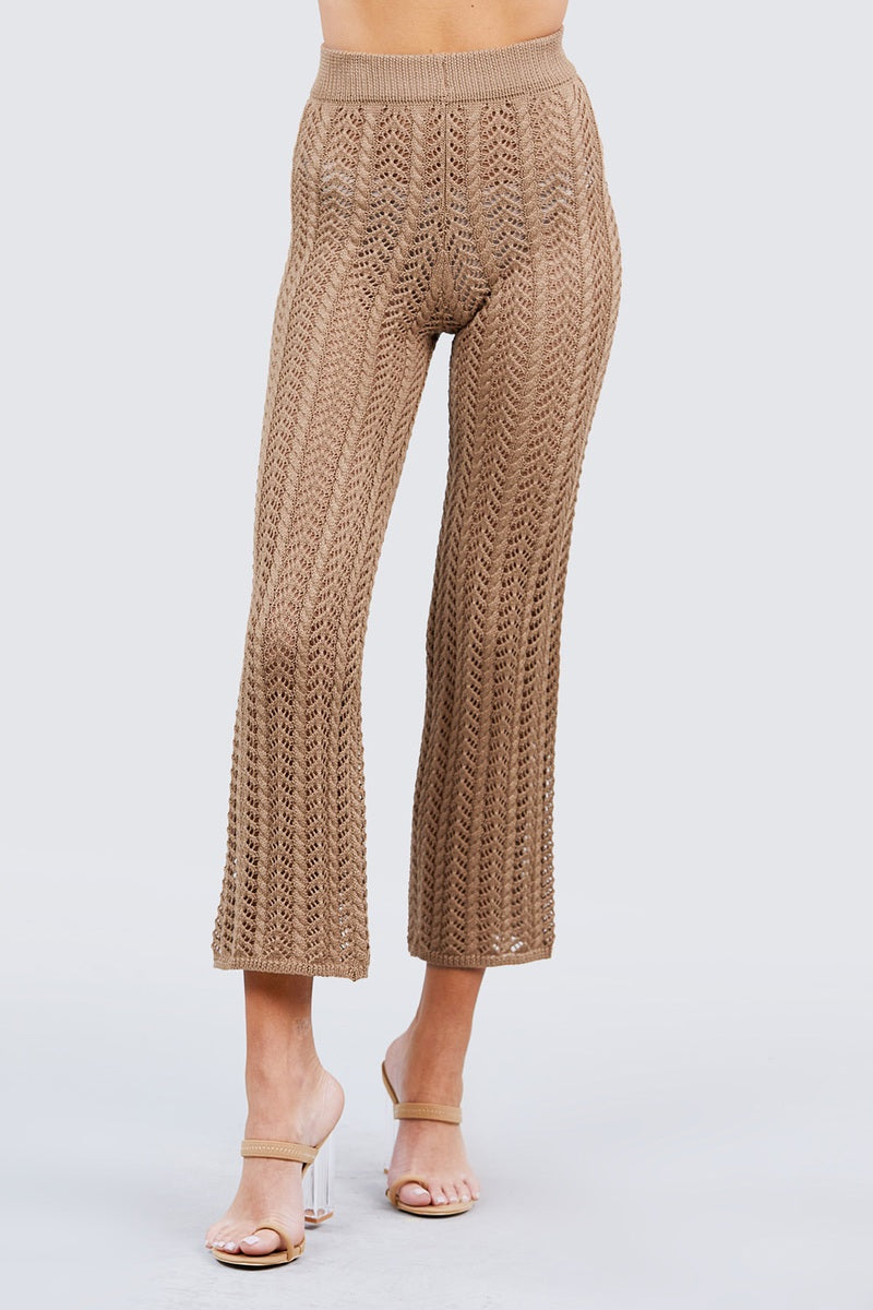 Khaki knitted pants worn by a person on a light gray background