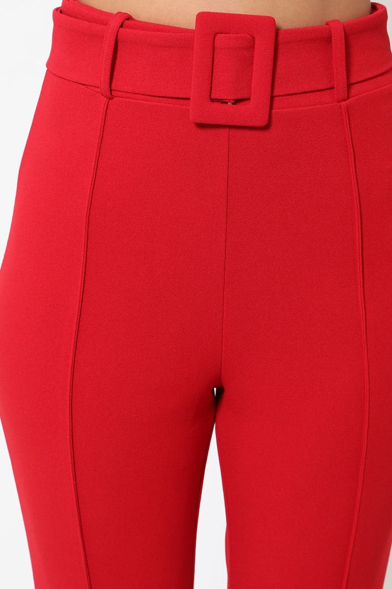 Close-up of red pants with a belt on a white background 