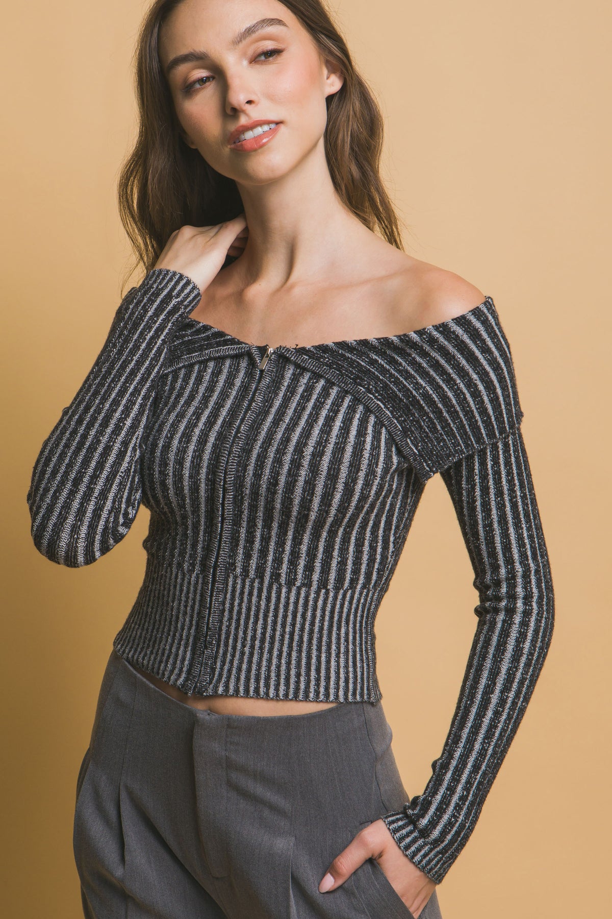 Woman wearing a ribbed bardot black and white striped off-shoulder top close up