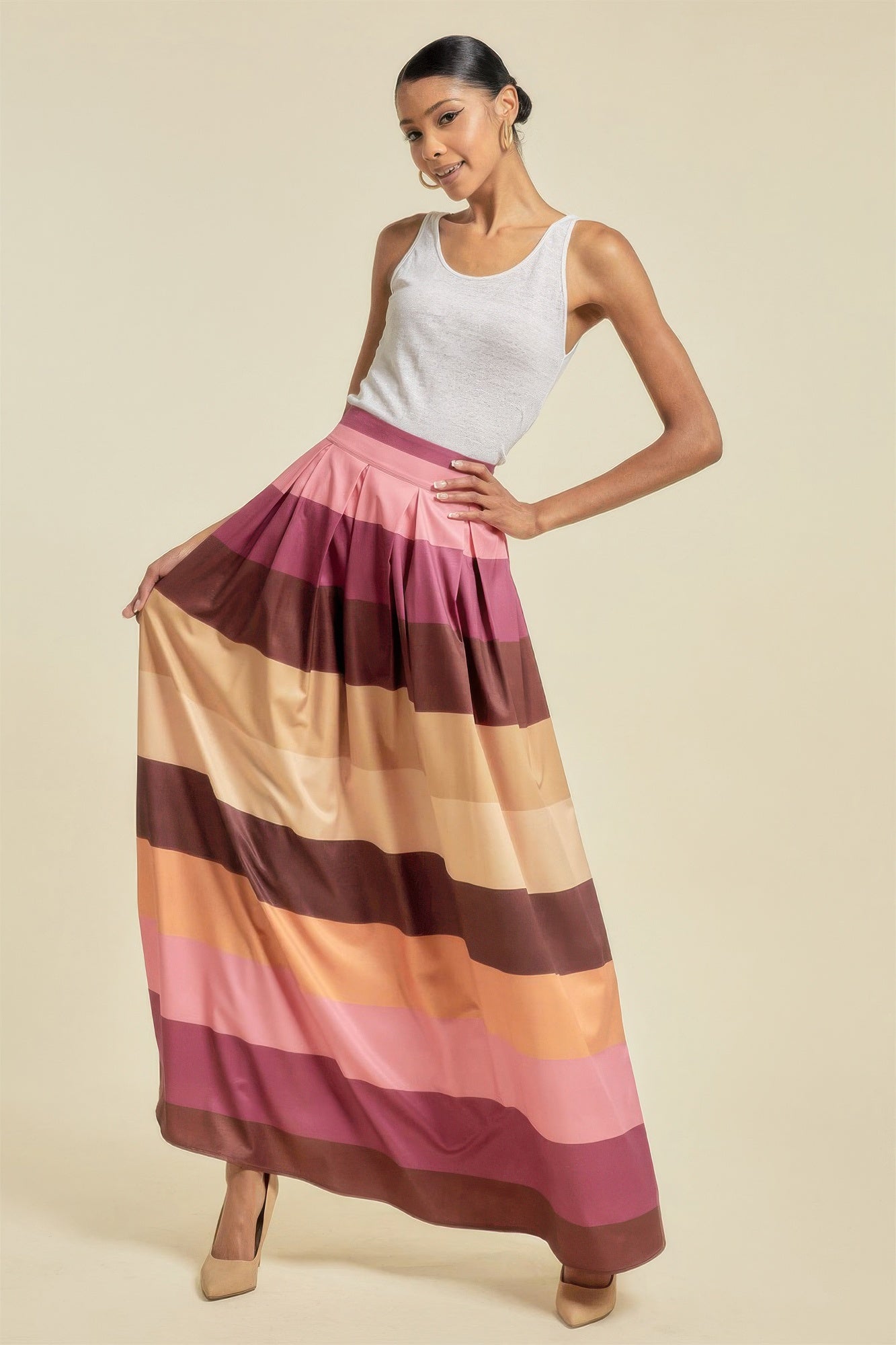 Woman wearing a long, striped skirt with a neutral background