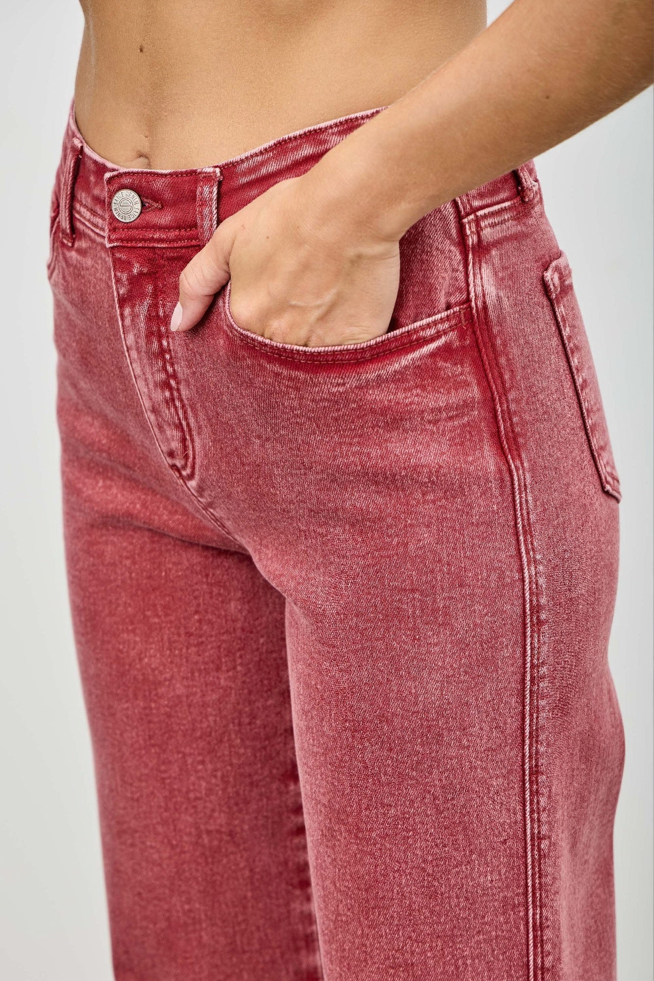 Red jeans pocket view worn by a person on a plain background