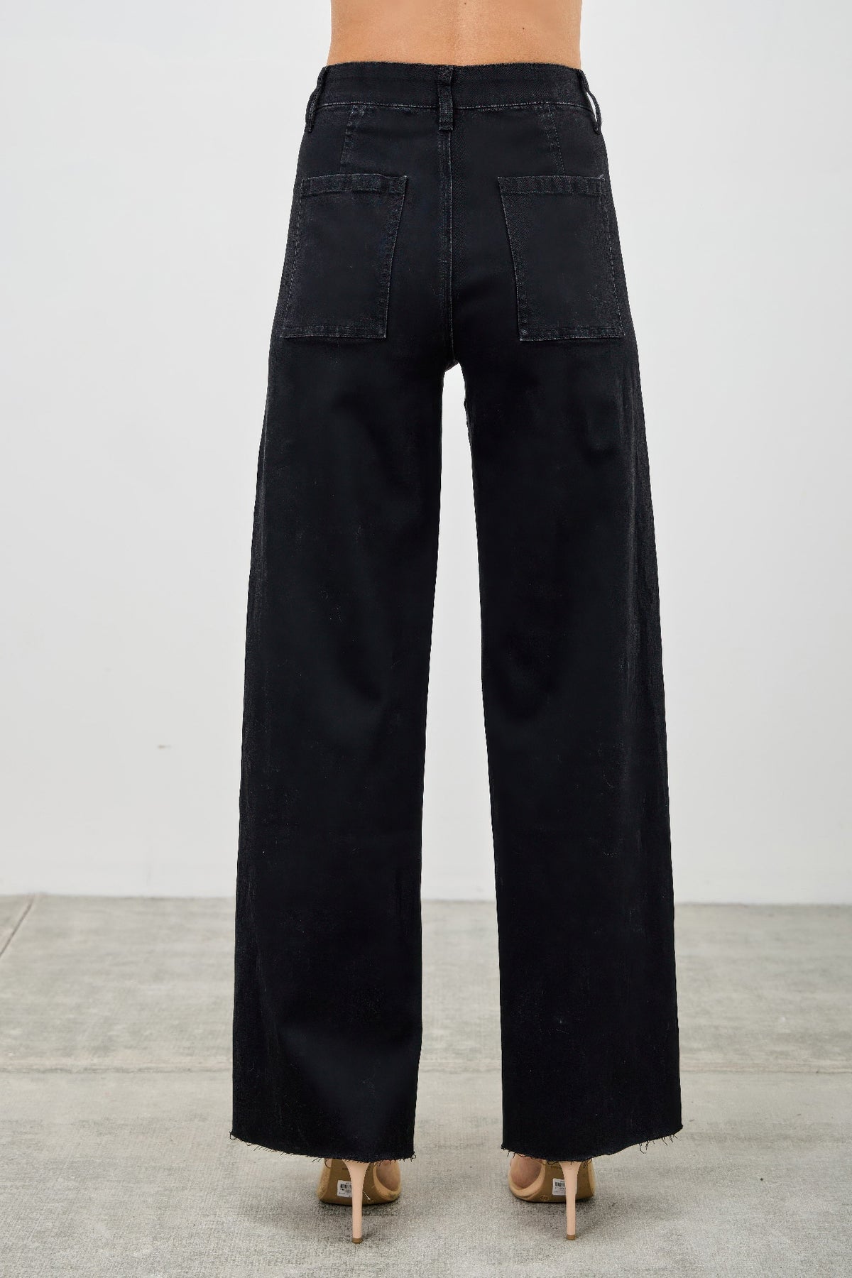 Black wide-leg jeans worn by a person on a light gray background back view