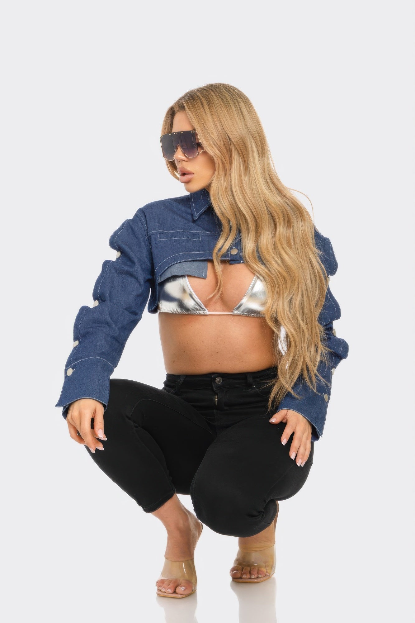Woman wearing a blue denim jacket and black pants on a white background