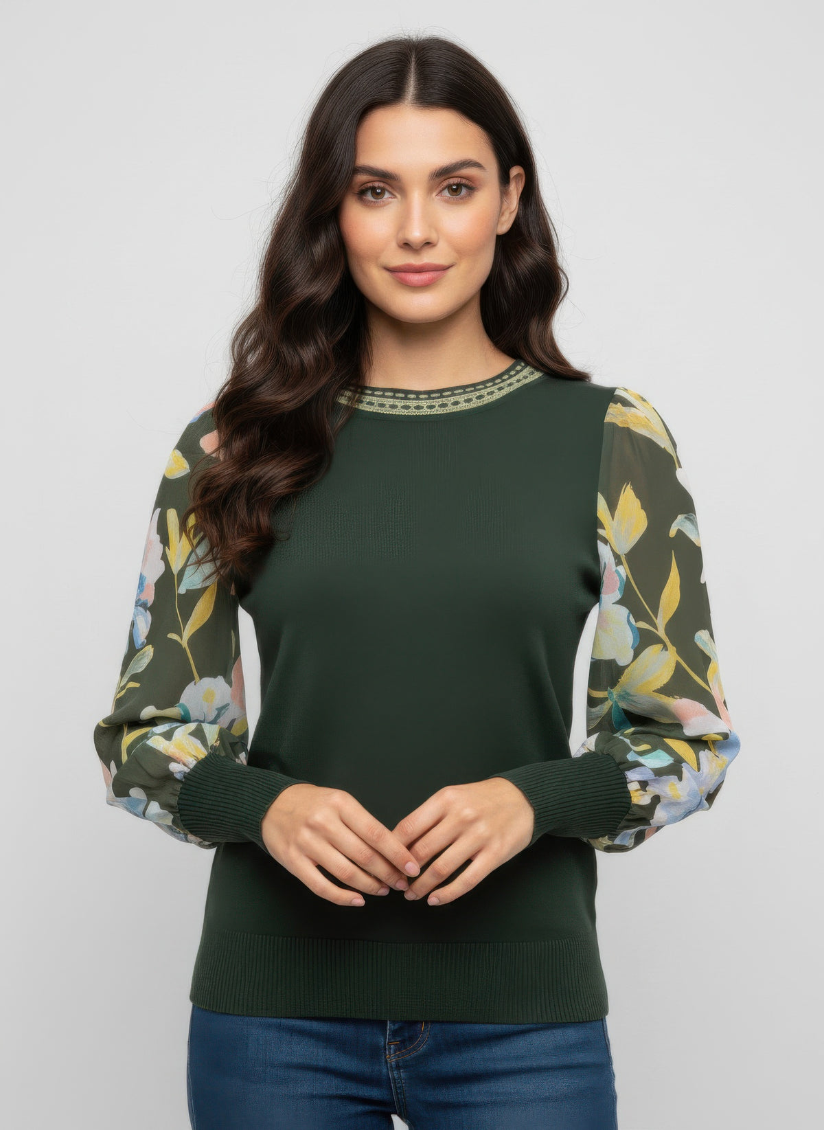 Woman wearing a green rio & rian sweater with floral sleeves against a plain background