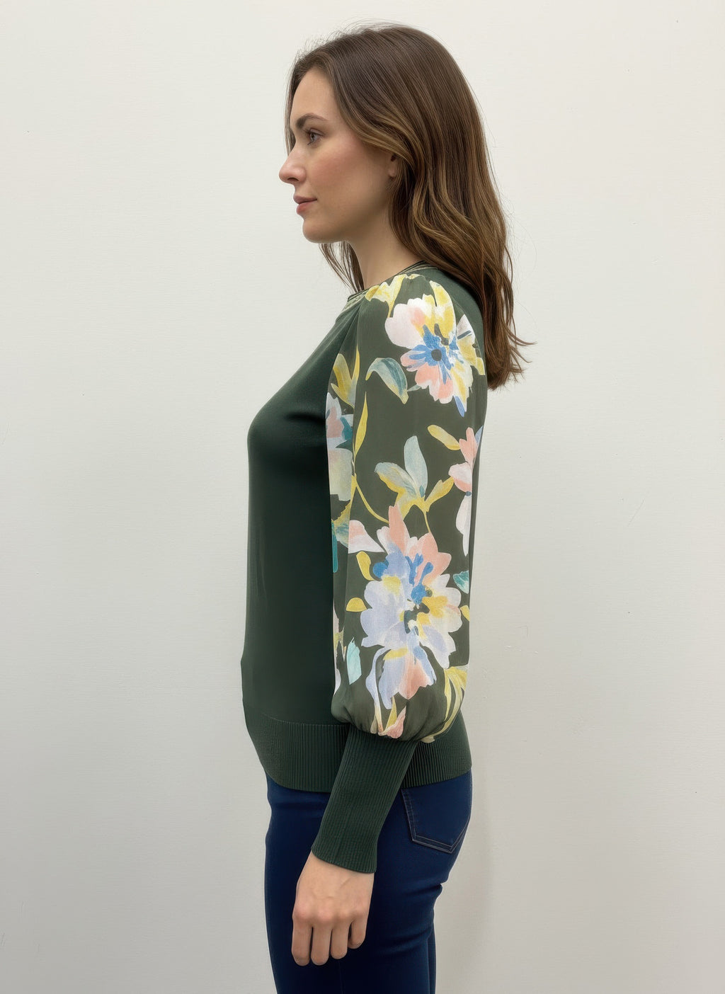Woman wearing a green rio & rian sweater with floral patterns side view