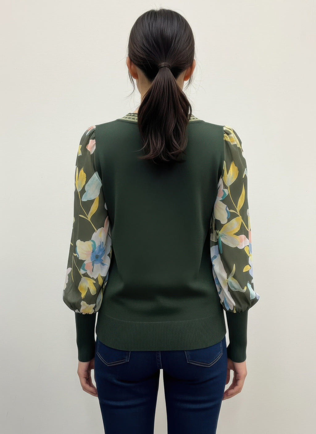 Person wearing a green rio & rian sweater with floral sleeves back view
